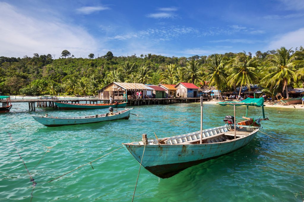 Barcas de pescadores de madera y casas sobre pilotes en la costa de Kep, Camboya