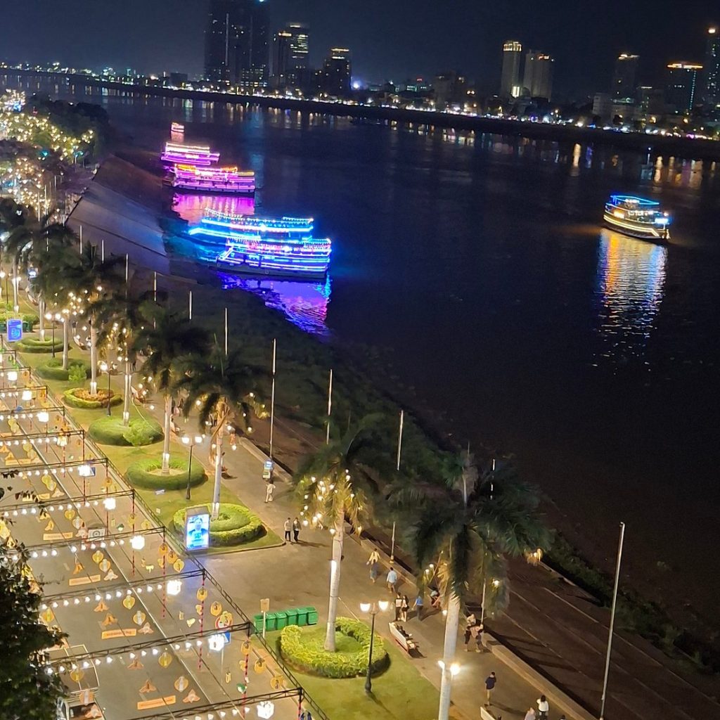 Cruceros iluminados en el río Tonlé Sap frente al Muelle Sisowath, Phnom Penh, de noche